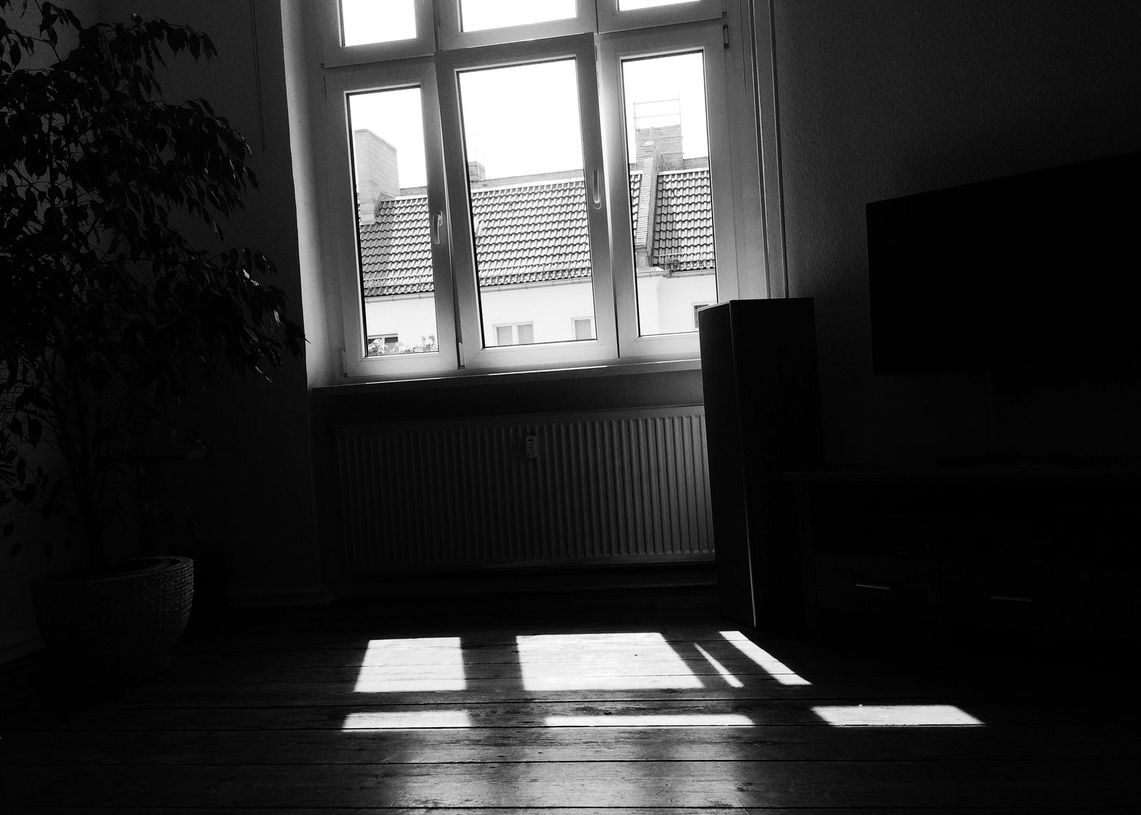 Lege kamer waar zonlicht door het raam op de vloerdelen valt