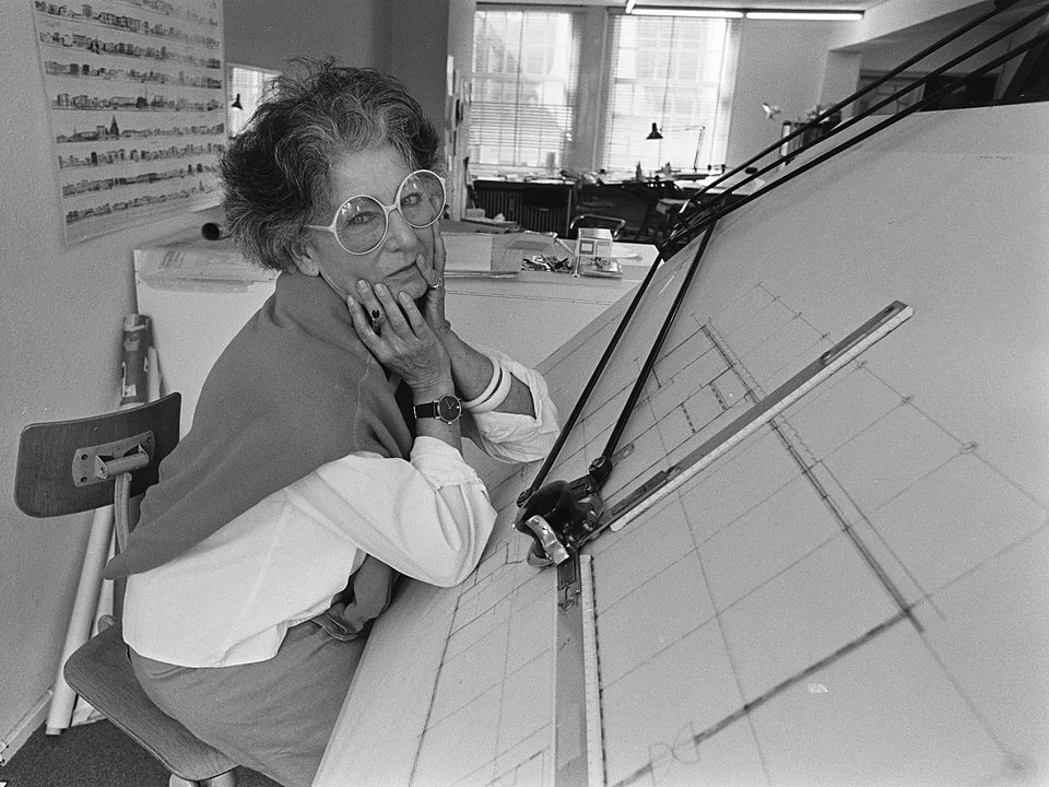 Architecte achter haar tekentafel, denkend over de tekening voor haar